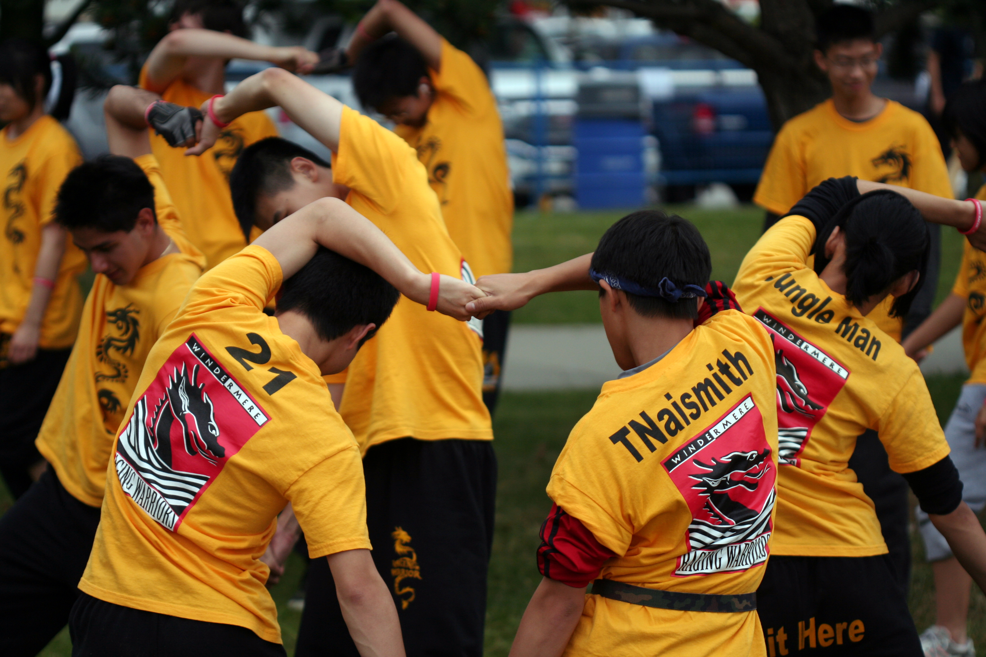 People stretching arms overhead — warming up before activity